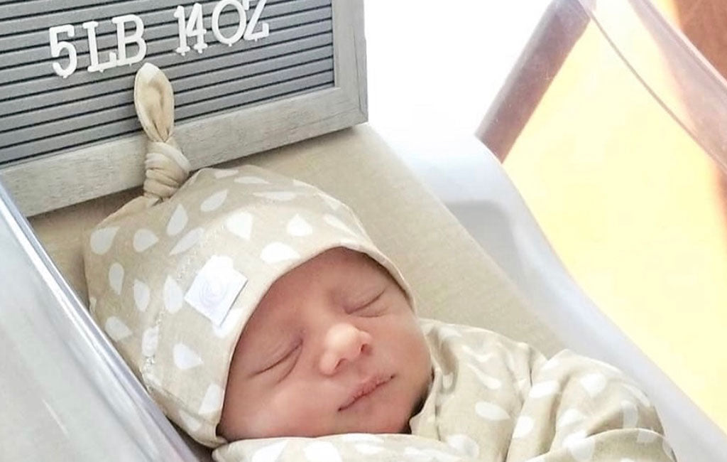 Newborn Wearing A Newborn Nest Top Knot Hat